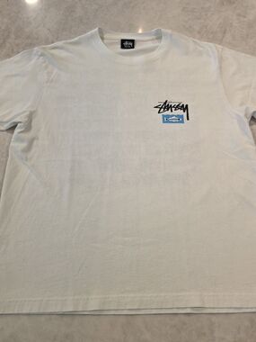 Stussy White Short Sleeve Tee with Black Logo and Blue Patch